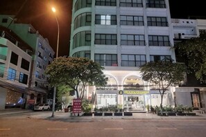 A hotel with a curved facade, multiple floors, and a well-lit entrance. - KIM A HOTEL (Bac Ninh)