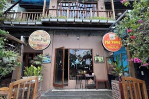 A cafe with a wooden facade, a balcony, and outdoor seating. - KIM A HOTEL (Bac Ninh)