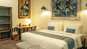 A bedroom with a bed, bedside table, lamp, and artwork on the wall. - Roka Resort by ARKasia Foundation (Bintan)