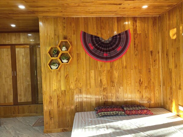 Ein Zimmer mit Holzwänden, einem Bett, einer Wanddekoration und sechseckigen Regalen mit Pflanzen.