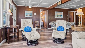 A room with two massage chairs, a wooden ceiling, and a view of the outdoors. - Safe Haven Cottage- Beach, Shopping, Fun! (Surf City)