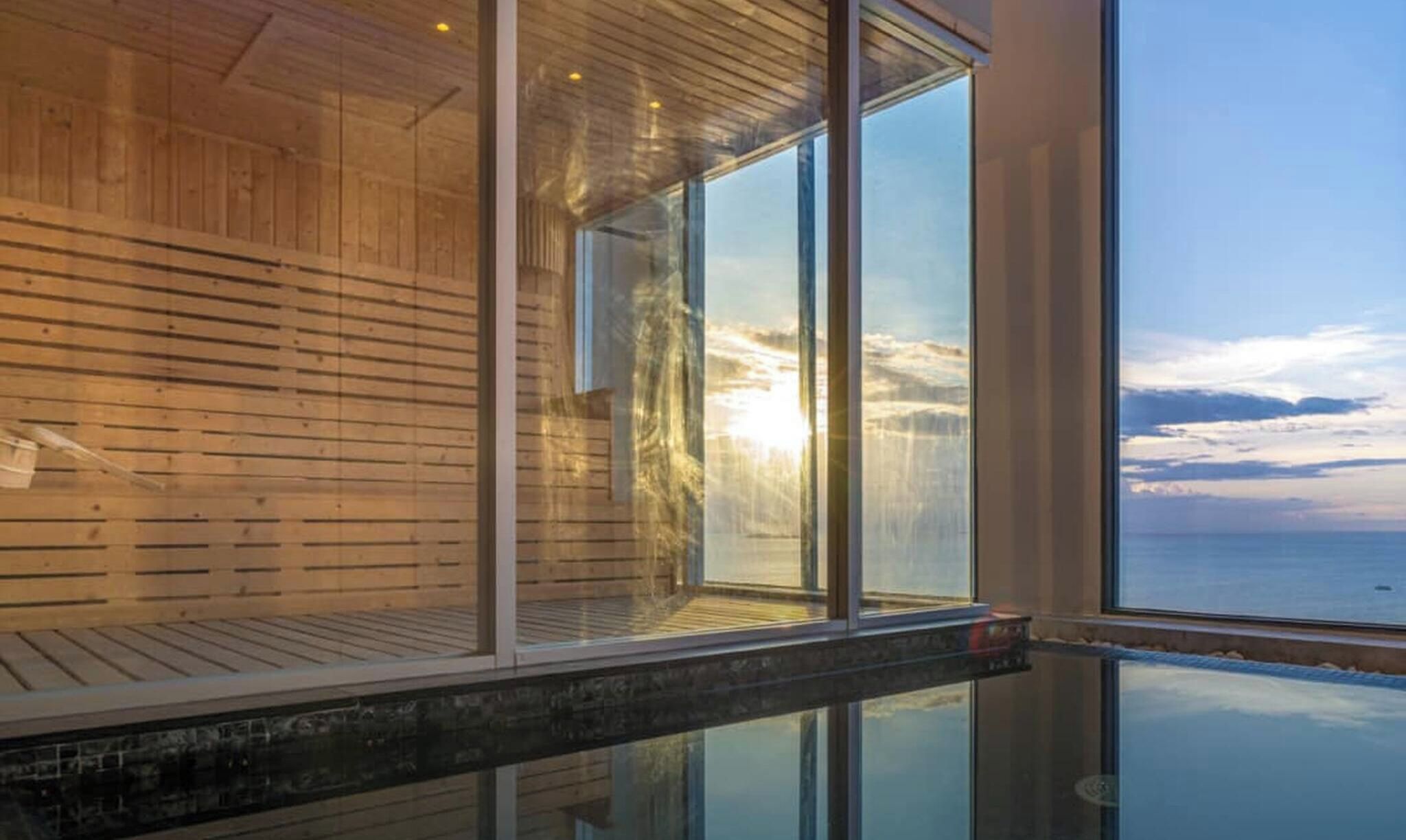 A modern interior with wooden paneling and large windows offering a view of the sea.