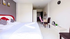 Ett modernt hotellrum med en stor säng, ett skrivbord och en stol.