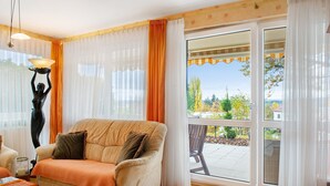 Ein Wohnzimmer mit einer Couch, einem Glastisch und einer Statue.