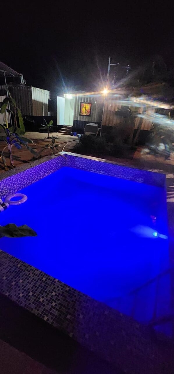 A swimming pool with a blue tint, surrounded by a tiled deck. - Aviator Resort (Arambol)
