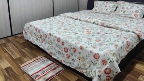 Ένα υπνοδωμάτιο με ένα κρεβάτι, ένα κλιματιστικό, έναν ανεμιστήρα οροφής και ένα ξύλινο δάπεδο.