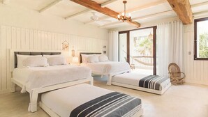 A room with two beds, a wooden ceiling, a wicker chair, and a view through a glass door. - Villa La Semilla • 5BR Beachfront w/ Chef (Tulum)