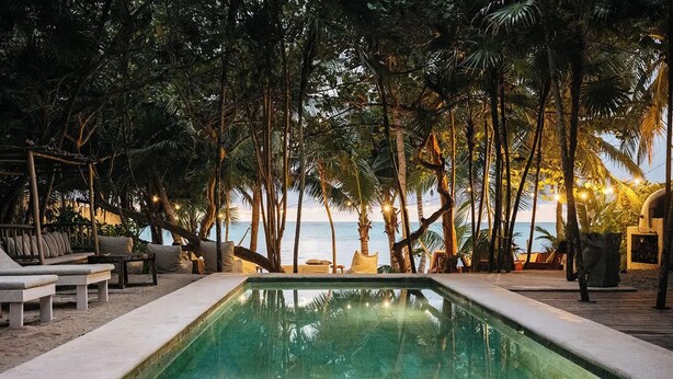 A pool area with lounge chairs and a view of the ocean. - Villa La Semilla • 5BR Beachfront w/ Chef (Tulum)
