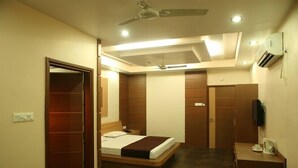 A modern bedroom with a bed, wardrobe, and a TV. - Golden Retreat Guest House (Kolkata)