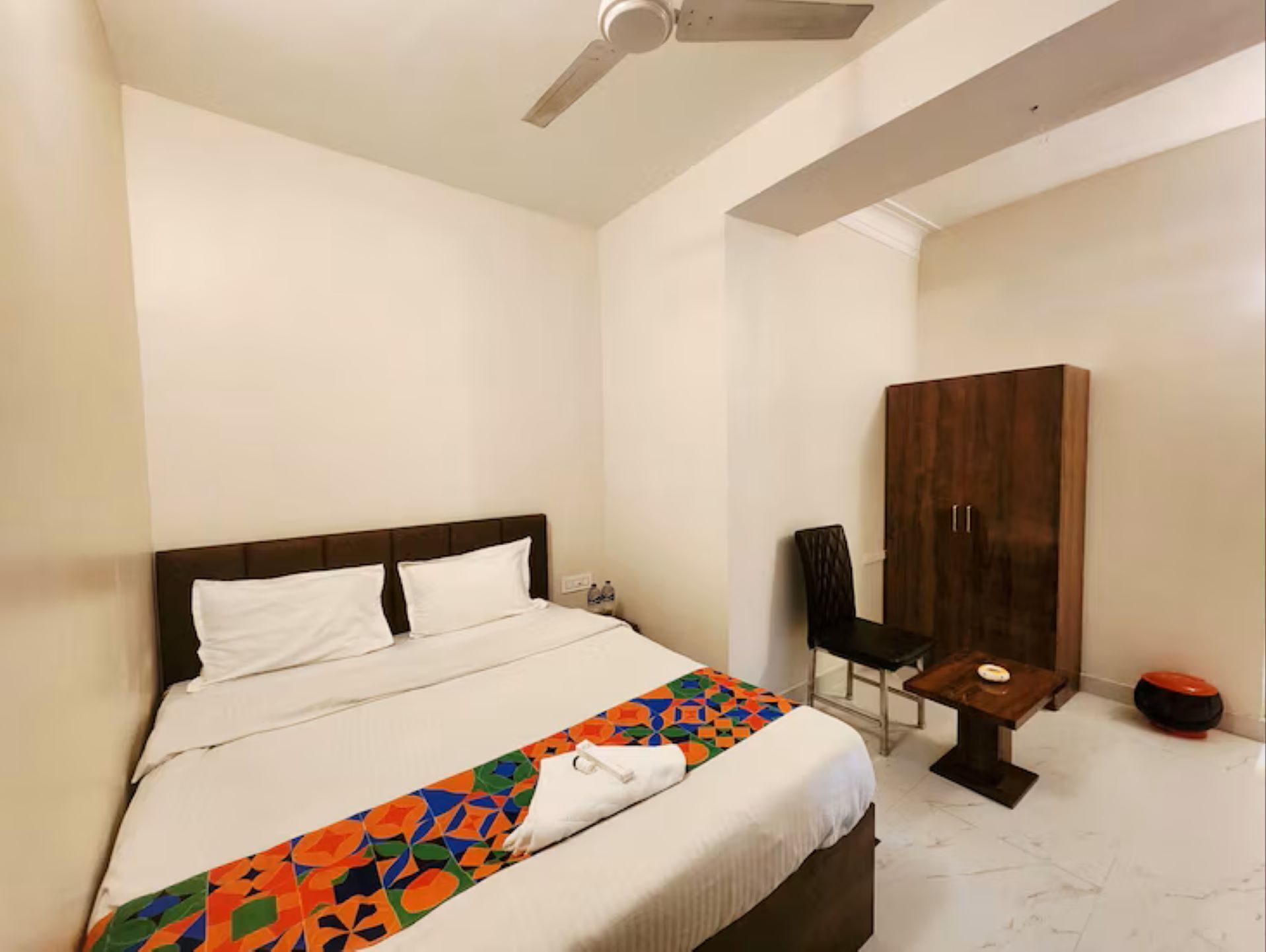 A bedroom with a bed, a desk, a chair, and a wardrobe.