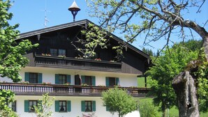 A two-story building with a balcony and a tower-like structure on the roof. - Apartment 38 sqm living/bedroom and terrace, App. 4 (Aschau im Chiemgau)