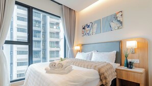 Habitación de hotel con una cama grande, dos lámparas de noche, una mesita de noche y una ventana con cortinas.
