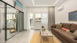 A modern living room with a sofa, coffee table, and a painting on the wall.
