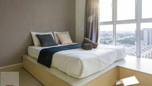A modern bedroom with a bed, pillows, and a view of the city through large windows. - Rumahku LRT, Ara Damansara, near Subang Airport (Petaling Jaya)