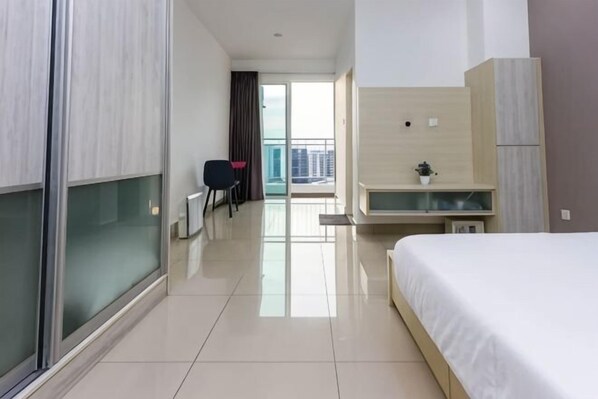 A hotel room with a bed, a desk, a chair, and a view of the city. - Rumahku LRT, Ara Damansara, near Subang Airport (Petaling Jaya)