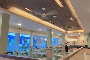 Un intérieur de restaurant moderne avec un bar, des espaces de repos et un comptoir bien visible.