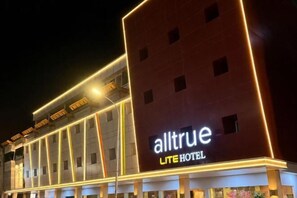 Un hôtel doté d’une enseigne bien visible indiquant « alltrue LITE HOTEL » et présentant une architecture moderne.