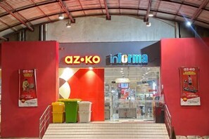 L’entrée d’un magasin avec une façade rouge et une enseigne indiquant « az·ko informa ».