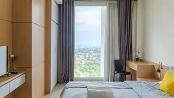 A modern hotel room with a large bed, a desk, and a chair.