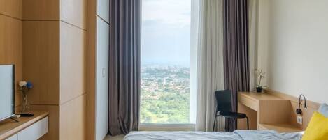 A modern hotel room with a large bed, a desk, and a chair.