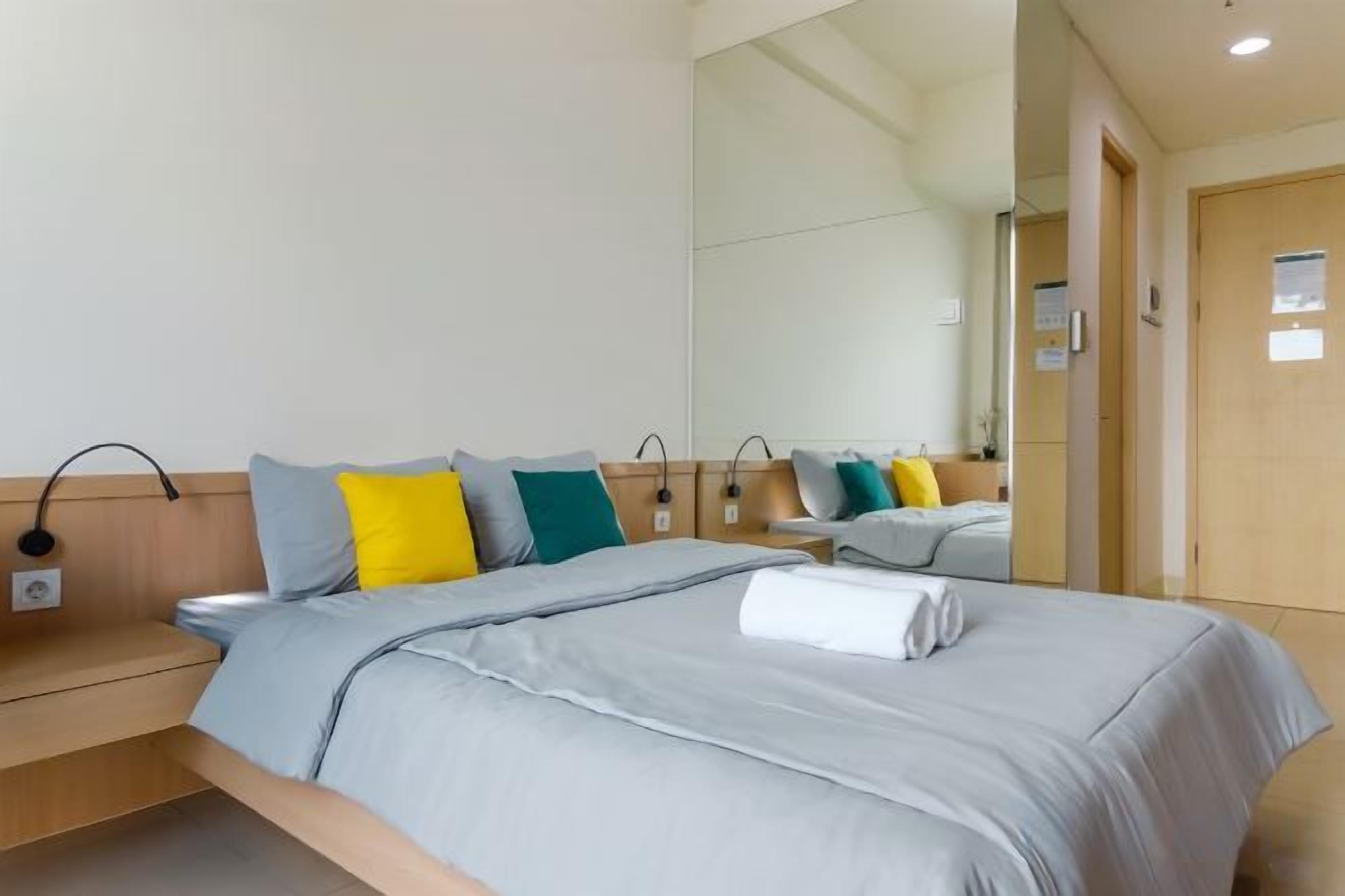 Ein Hotelzimmer mit einem Bett, Nachttischen, einem Spiegel und einer Tür.