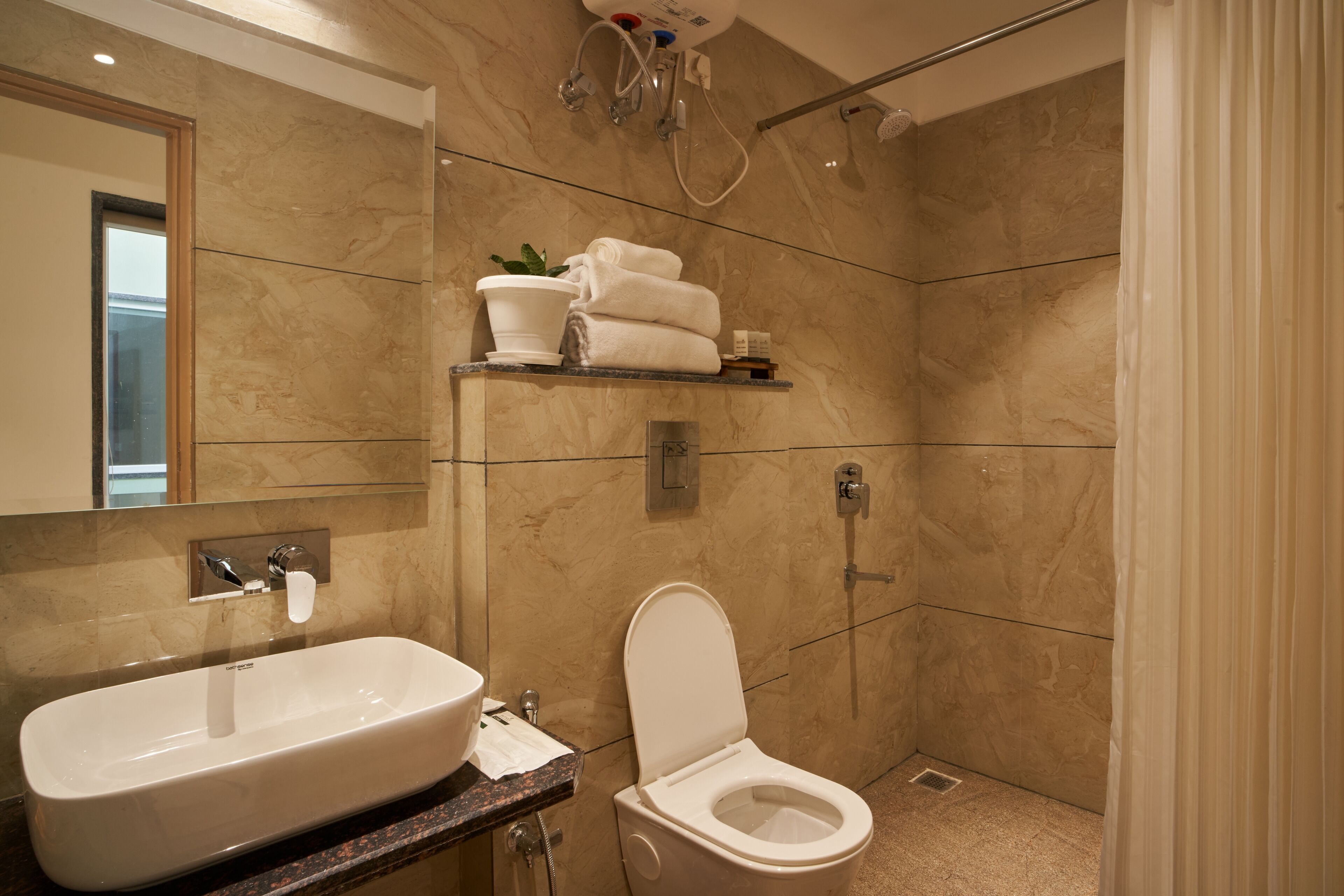 Un baño moderno con lavamanos, inodoro y ducha.