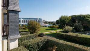 A hotel with a modern design, a landscaped garden, and a view of a body of water. - Studio L'Océanic, summer pool, near beach and port, parking, towels & cleaning extra (Arzon)