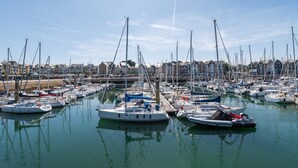 A marina with numerous boats docked, calm water, and buildings in the background. - Studio L'Océanic, summer pool, near beach and port, parking, towels & cleaning extra (Arzon)