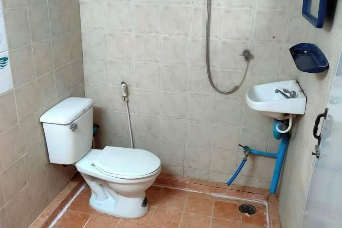 A small bathroom with a toilet, a shower, and a sink.