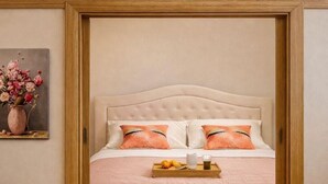 Un dormitorio con cama, dos mesitas de noche, una alfombra mullida y un cuadro en la pared.
