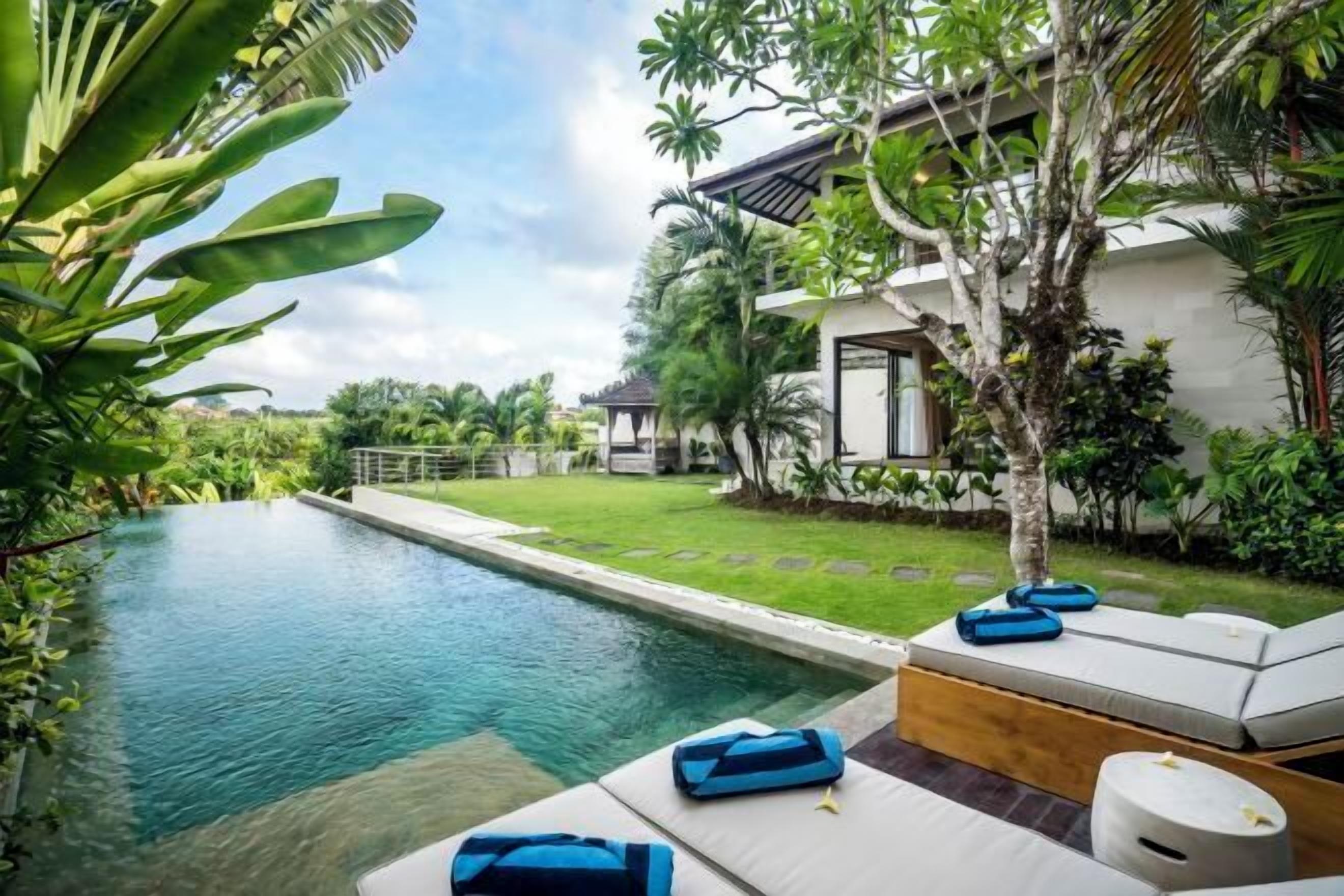 A poolside area with lounge chairs and a small wooden deck.