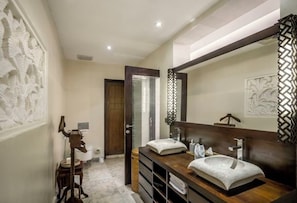A modern bathroom with a wooden vanity, two sinks, and decorative wall panels.
