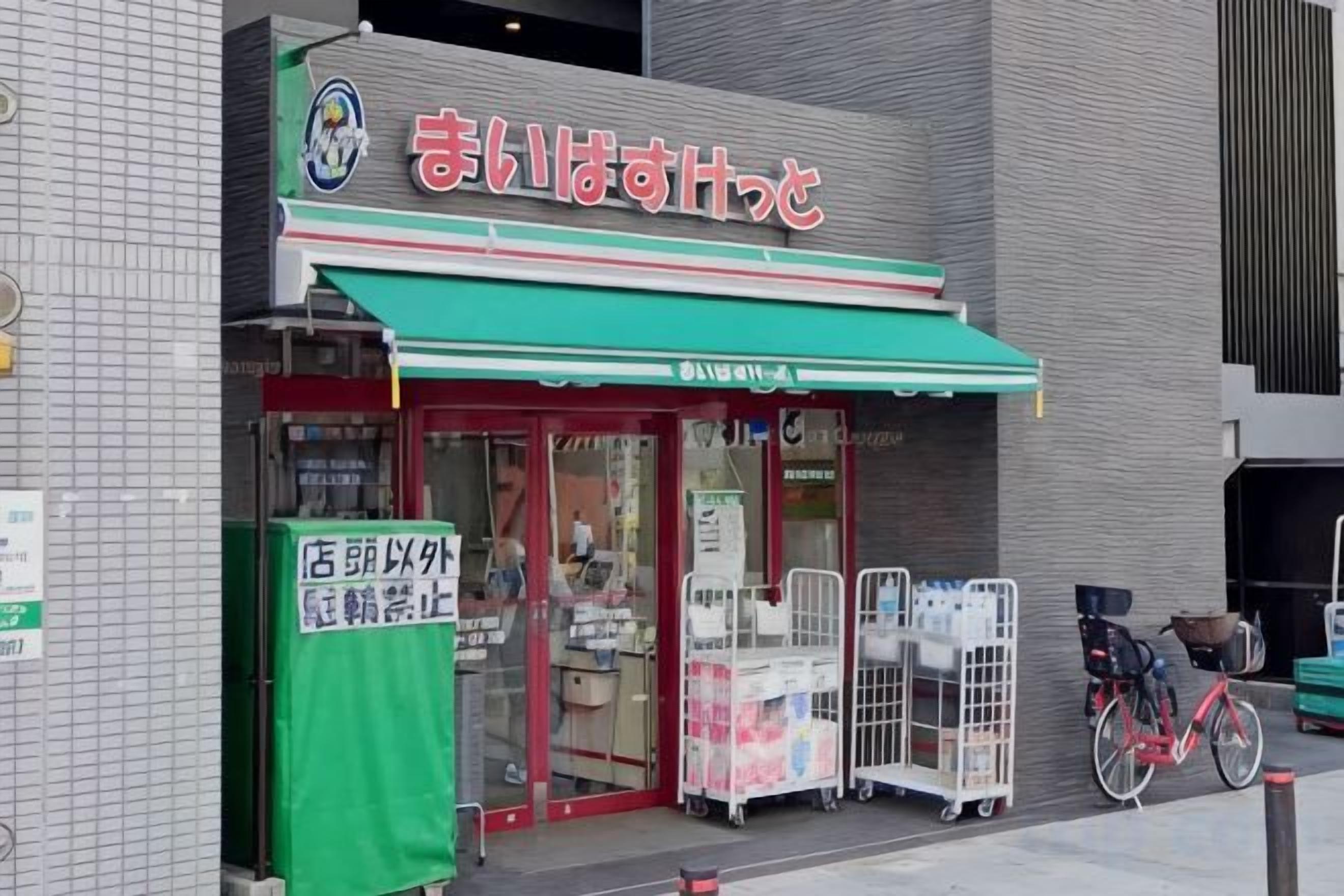 A storefront with a green awning and a sign in a foreign language.