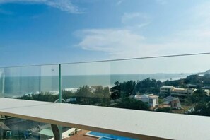 Un balcon offrant une vue dégagée sur une piscine et les bâtiments environnants.