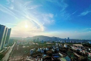 A cityscape with modern buildings, a clear sky, and a distant mountain range. - Bap's House - CSJ Apartment Vung Tau (Vung Tau)