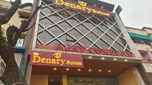 En byggnad med skyltar som visar namnen ”Denary Suites” och ”Ajay Complex”.