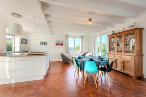 A dining area with a wooden table, chairs, and a cabinet with glass doors.