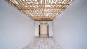 Un couloir doté d’un plancher en bois et d’une structure de plafond en bambou.