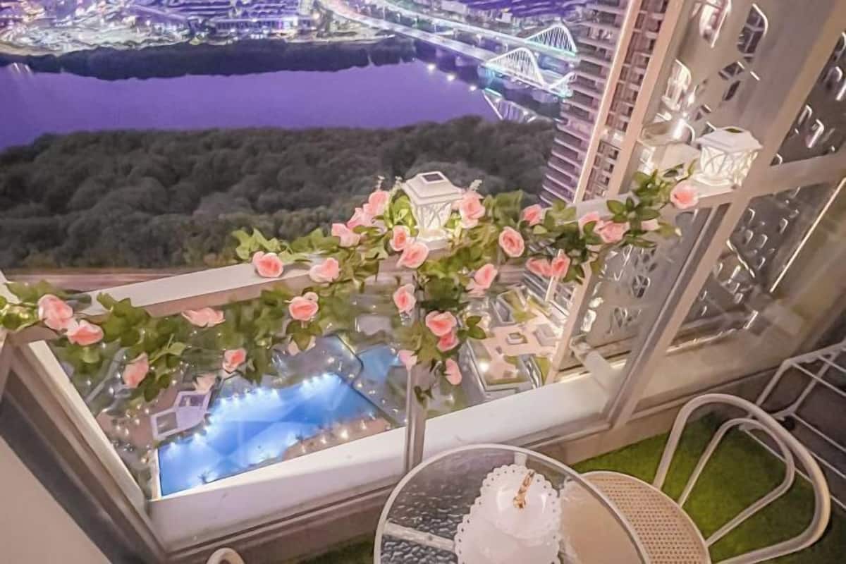 Een balkon met uitzicht op een stadsbeeld en een rivier 's nachts.