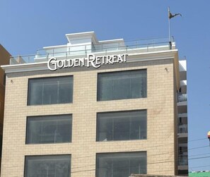 A building with the sign "Golden Retreat" indicating a hotel or retreat center. - Golden Retreat (Puri)