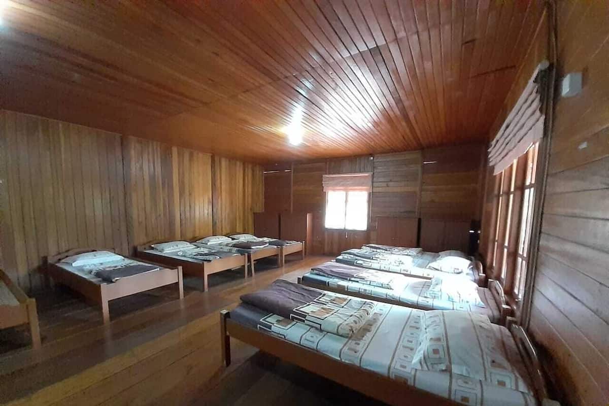 Een houten chalet met bedden en een groot raam.