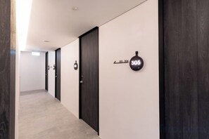 A hallway with doors, a wall-mounted sign, and a light fixture. - Heritage Collection on Pagoda - Mobile App Check-In (Singapore)