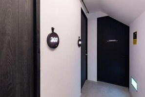 A hallway with a door labeled '207' and a sign above it. - Heritage Collection on Pagoda - Mobile App Check-In (Singapore)