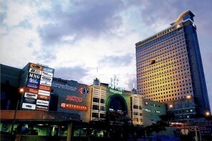 A hotel with a prominent sign, a large building with many windows, and a clear sky. - KL Gateway Residence (Kuala Lumpur)