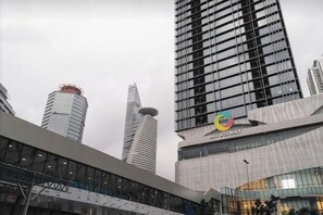 A modern building with a glass facade and a distinctive logo. - KL Gateway Residence (Kuala Lumpur)