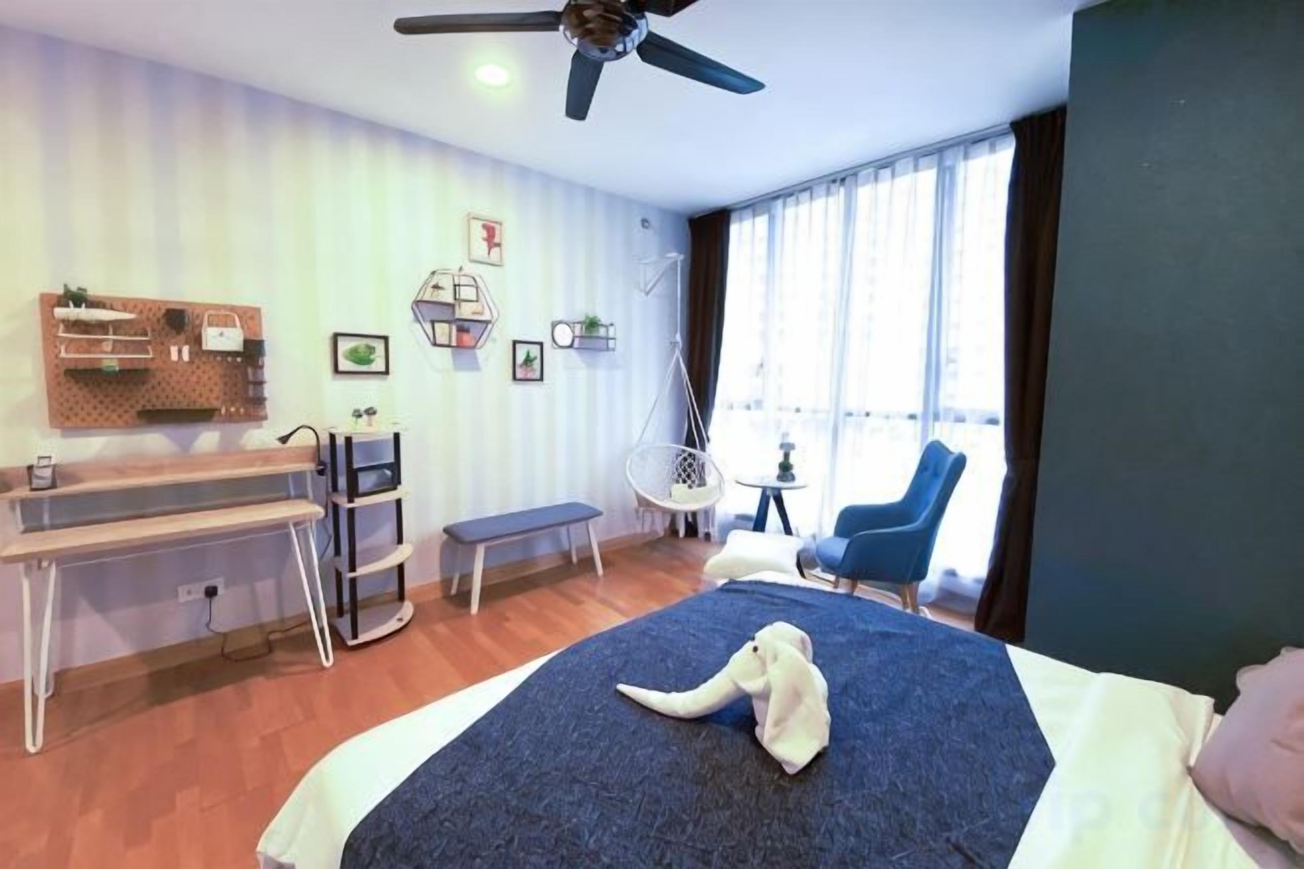 A bedroom with a bed, a desk, a chair, and a window with curtains.