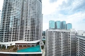 A high-rise building with a curved facade, multiple balconies, and a swimming pool area. - KL Gateway Residence (Kuala Lumpur)