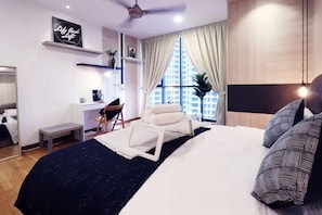 A modern bedroom with a bed, bedside table, chair, desk, and large window. - KL Gateway Residence (Kuala Lumpur)