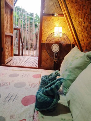 A room with a bed, a fan, and a view of the outside. - Amwani Beach Camp (El Nido)