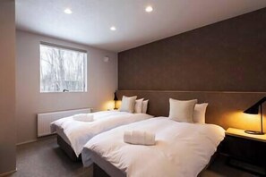 A hotel room with two beds, a large window, and a wall-mounted lamp. - Ukiyo | 3BR - Niseko Village Chalet near Annupuri Slopes (Niseko)